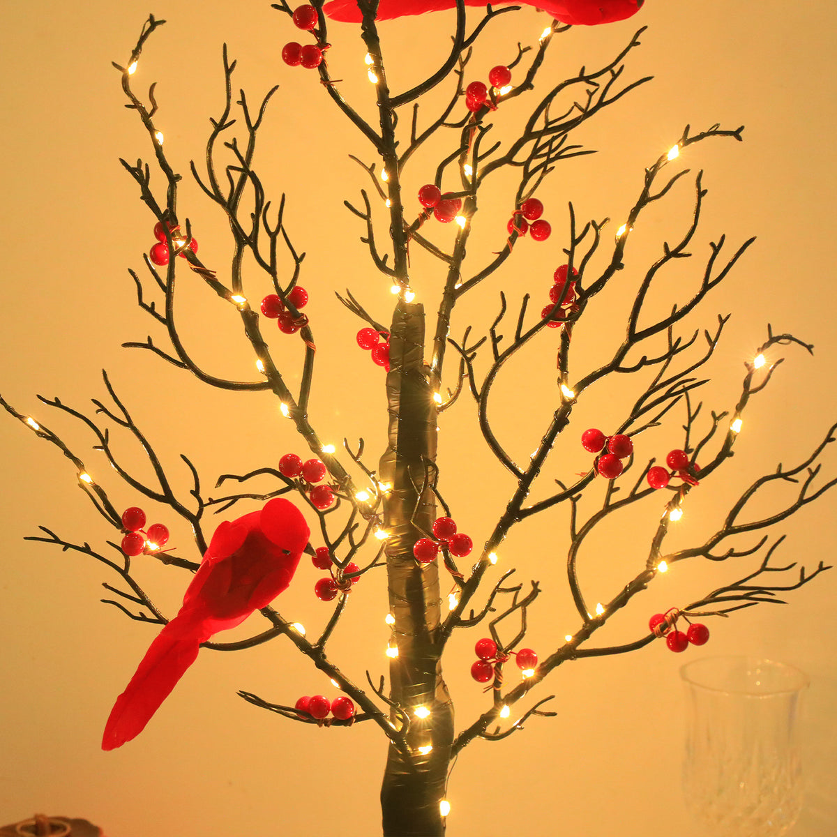Warm LED lights on dark branches with red berries