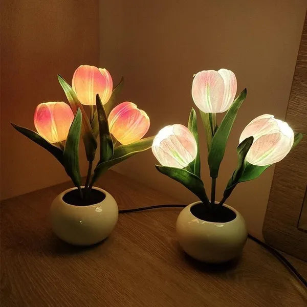 Pink and white glowing tulip lamps on a wooden table