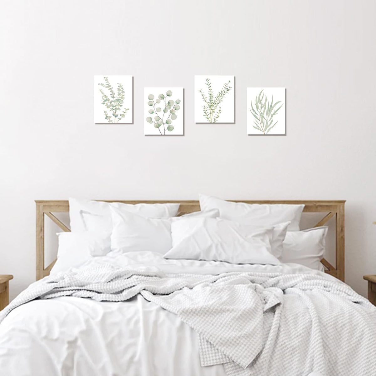 Botanical canvas prints in a row above a bed